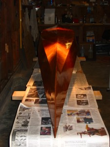 I spent all of Sunday removing wires and sanding. I did the same on Monday, Tuesday and Thursday nights (we had childbirth class on Wednesday). Saturday, I spent the day doing one final fine-grit sanding then I organized the shop a bit and applied the first coat of epoxy to the hull. What a difference! The boat isn't ugly anymore!